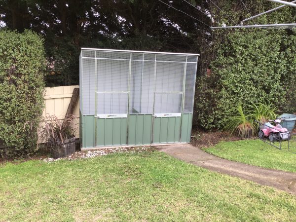 Custom Aviary with divider on concrete.